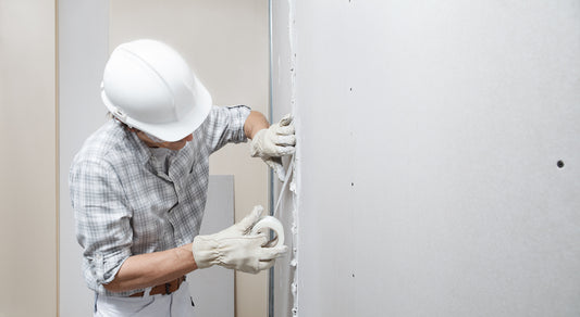 Man applying paper tape on drywall